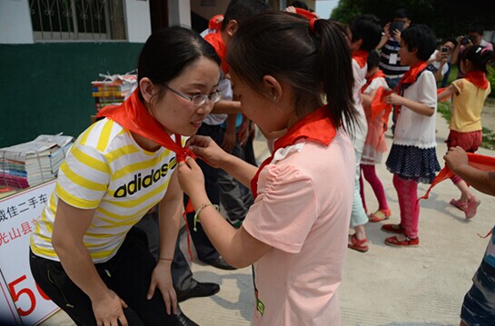 捐贈儀式上，孩子們?yōu)閻坌奶焓瓜瞪霞t領(lǐng)巾