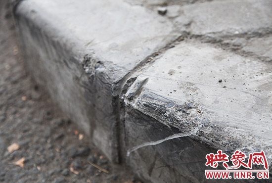 車(chē)道邊上的臺(tái)階，滿是電動(dòng)車(chē)摔下碰撞的痕跡