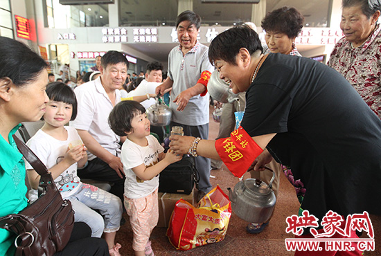 老年雷鋒團(tuán)”志愿者在候車(chē)廳為旅客送水。