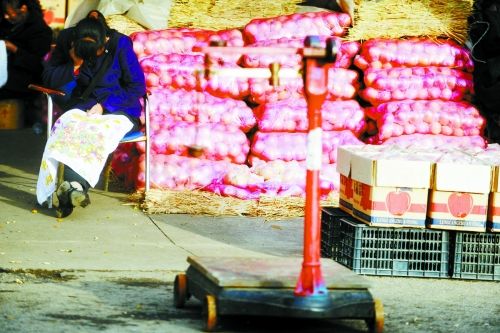 水果批發(fā)市場內(nèi)，沒有客戶時(shí)，商戶在繡十字繡