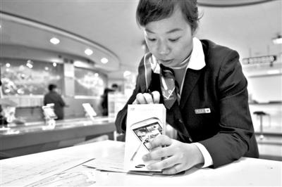 11月6日，北京移動西直門營業(yè)廳的工作人員在為顧客購買的4G手機登記。新華社發(fā)