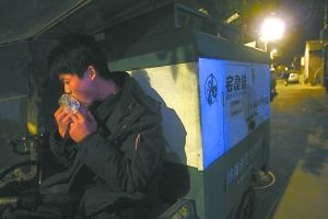 快遞哥抽空吃兩口東西。記者 李剛 攝