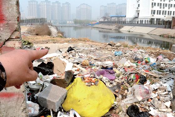 金水河長江路橋下河水發(fā)臭，水邊堆放眾多垃圾