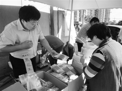 昨日，河南企業(yè)家劉春喜在京“練攤”，為顧客挑選綠豆。新京報(bào)記者 張玉學(xué) 攝