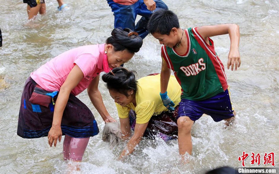 7月9日，村民在小河里摸魚搶魚。譚凱興 攝