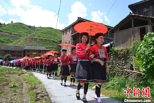 圖為新娘身著瑤族盛裝在伴娘和親友的陪伴下“出嫁”。中新社發(fā) 韋吉陽(yáng) 攝