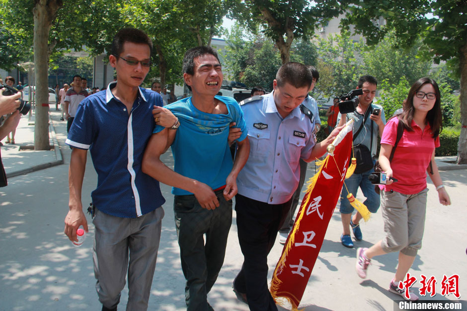 圖為獲救嬰兒父親情緒一度失控，當(dāng)?shù)鼐焦ぷ魅藛T對(duì)其進(jìn)行攙扶。張一辰 攝