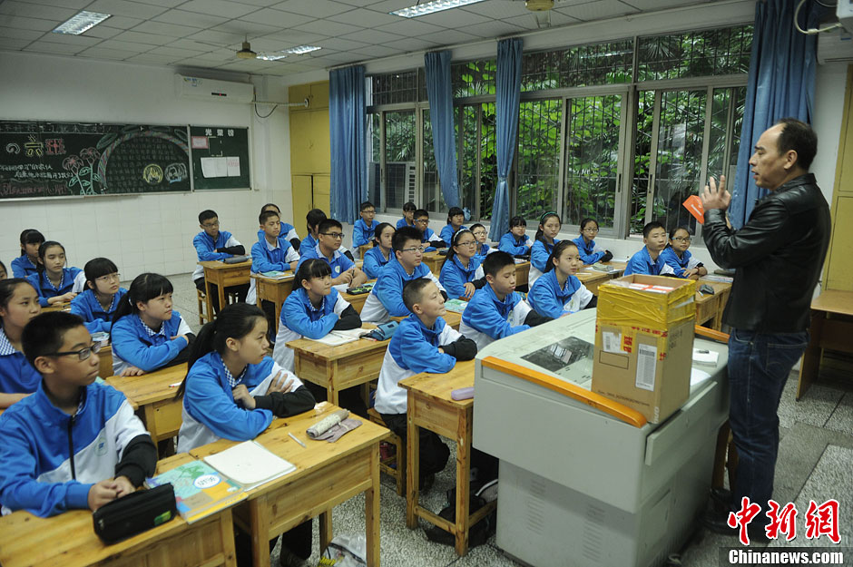 圖為老師正在向同學(xué)們講解用非智能手機(jī)對他們的好處。