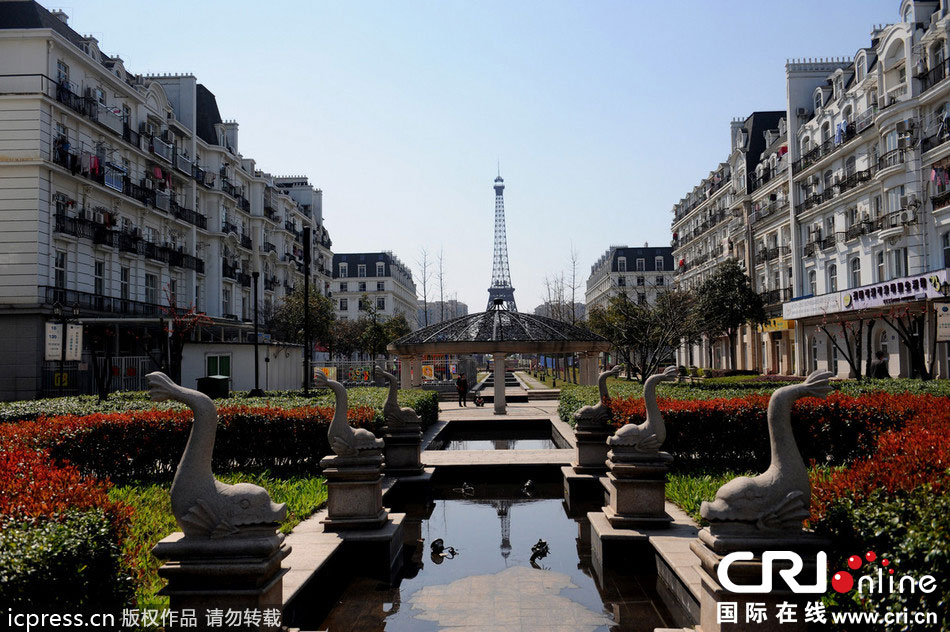 　2014年3月21日，杭州天都城，農(nóng)民在山寨埃菲爾鐵塔下耕作。圖片來源：東方IC