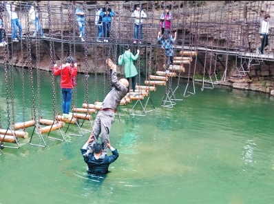 中年男游客正踩著景區(qū)安全員郭小明的肩膀過河。網(wǎng)友“@我的小名叫張孩”供圖