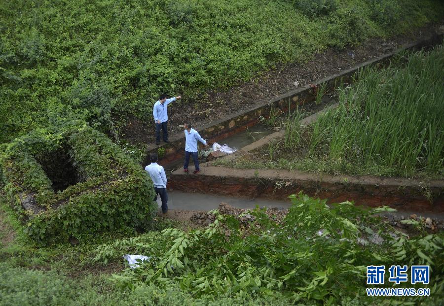 5月18日，工作人員在槽罐車泄漏現(xiàn)場(chǎng)附近的水渠邊查看情況。