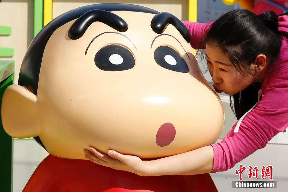 4月22日，游客與蠟筆小新合影。“蠟筆小新25周年紀(jì)念特展”日前在北京開展，吸引了不少市民游客。