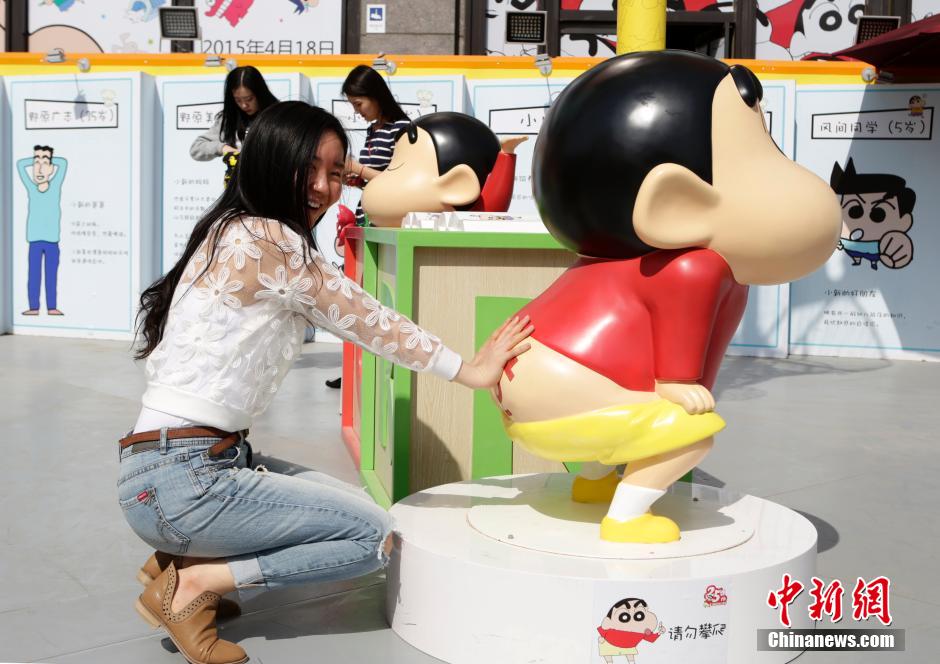 4月22日，游客與蠟筆小新合影。“蠟筆小新25周年紀(jì)念特展”日前在北京開展，吸引了不少市民游客。