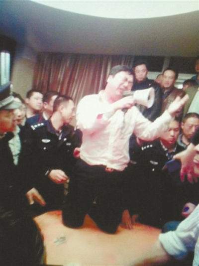 　4月19日，泰州市濱江工業(yè)園區(qū)管委會(huì)招待中心，一男子跪在酒桌上喊話求饒。李根 攝