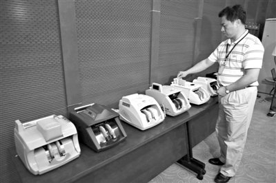 昨日，央行工作人員用各種驗(yàn)鈔機(jī)對C1F9假幣進(jìn)行測試，機(jī)器均能及時作出異常報警反應(yīng)。新京報記者 浦