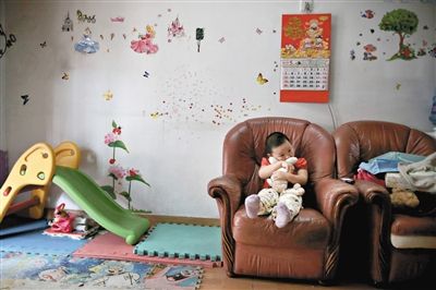 6月14日，未婚媽媽于軍的家里。女兒悅悅抱著兔子玩偶，在聽媽媽手機上的兒歌，這個4歲女孩喜歡兔子。