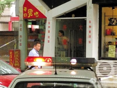 闖入面館的持刀男子與趕來的民警隔著玻璃門對峙，后店內(nèi)一名女童被其劫持。網(wǎng)友供圖
