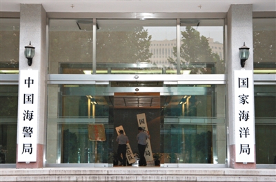 昨日，中國海警局掛牌成立。原國家海洋局和中國海監(jiān)總隊的牌匾被摘下，國家海洋局和中國海警局的新牌匾換上。黃冉 攝