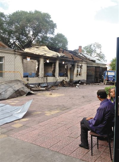 7月27日，海倫聯(lián)合敬老院內(nèi)，幾名老人看著對面被燒毀的特護(hù)病房。新京報記者 涂重航 攝