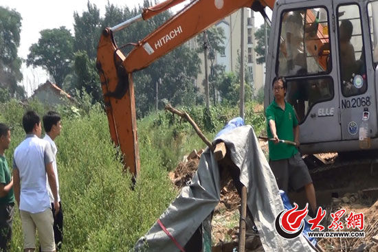 陳寶成手持自制刀斧守在挖掘機旁阻止便衣民警靠前。駕駛室內(nèi)，張朋珂正向受害人郭曉剛身上澆汽油。（視頻截圖）