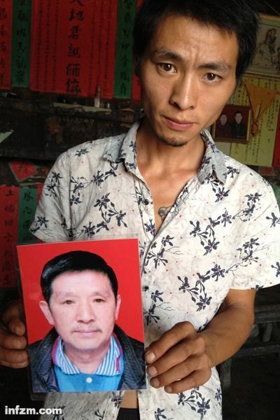 程興貴的兒子程正鵬拿著父親的遺照。程興貴自殺后，政府補償程家6000多塊錢，并終于認定了程興貴的代課教齡。 (南方周末記者雷磊/圖)