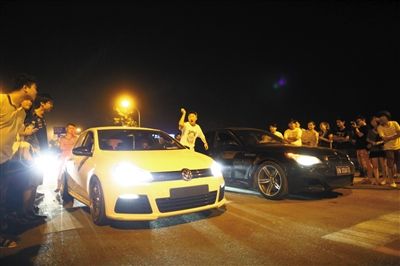 8月24日晚，東壩中街飆車現(xiàn)場，兩輛車并排等待出發(fā)指令，旁邊許多愛好者前來觀看比賽。新京報(bào)記者