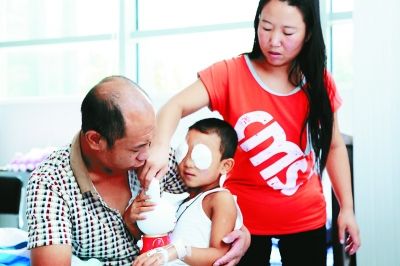 斌斌手術(shù)后第一天恢復(fù)良好，斌斌父母在用玩具逗他開心供圖/嚴益