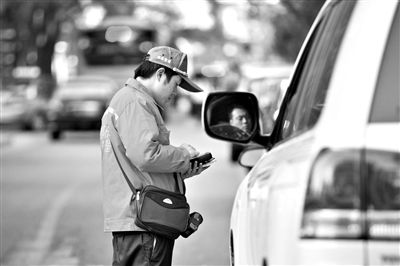 10月15日，朝陽區(qū)東大橋路，停車管理員從腰間掏出一個專用POS機，正在錄入停車信息。新京報記者 周崗峰 攝
