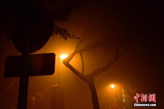 1月31日凌晨，市民行走在煙霧繚繞的南京街頭。當(dāng)天是農(nóng)歷馬年正月初一，南京有限開禁燃放煙花爆竹正逢下霧天，空氣的不流通致使煙花爆竹燃燒后產(chǎn)生的顆粒物不能及時(shí)散開，造成整座城市煙霧繚繞。據(jù)當(dāng)?shù)丨h(huán)保部門發(fā)布的信息顯示，空氣質(zhì)量屬重度污染。中新社發(fā) 泱波 攝