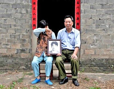 江蘇鎮(zhèn)江，老劉夫婦捧著獨生子的遺像在老家前留影南方都市報供圖L