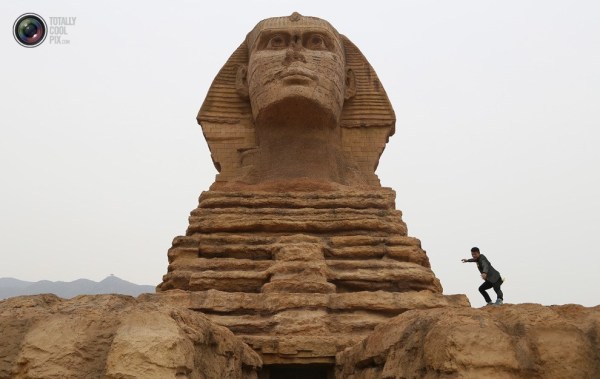 石家莊郊外，一名男子與山寨版獅身人面像合影留念。