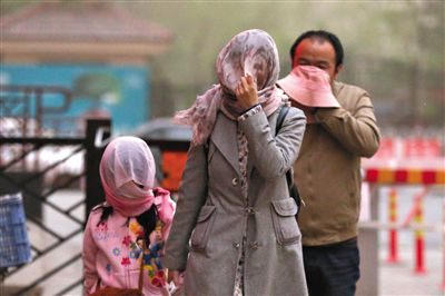 昨日下午，朝陽區(qū)豆各莊，行人將紗巾裹在頭上防沙塵。