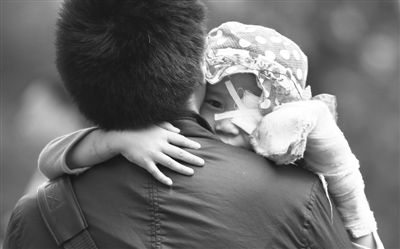 昨日，北京同仁醫(yī)院，被砍傷的彤彤趴在舅舅的肩上。他們剛剛掛完號，正準(zhǔn)備回旅館。新京報(bào)記者 尹亞飛 攝