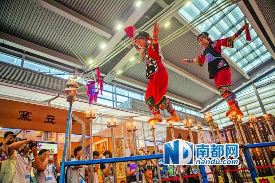 2號(hào)展館，苗族姑娘表演踩燈泡絕技《電光玫瑰》，赤腳踩上40瓦的燈泡并做出高難度動(dòng)作。 南都記者 霍健斌 攝