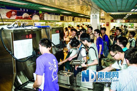 昨日，華南理工大學(xué)一食堂內(nèi)，學(xué)生們正在使用新安裝的自動(dòng)打飯機(jī)打飯。中新社發(fā)