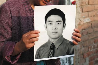 5月19日，朝陽(yáng)北路，母親捧著張東文的遺像。新京報(bào)記者 侯少卿 攝