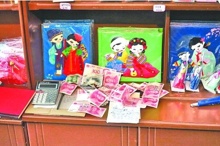 　　2012年6月21日，在朝鮮羅先特別市的一家商店里，柜臺上散落著一些人民幣。在朝鮮，人民幣比本國