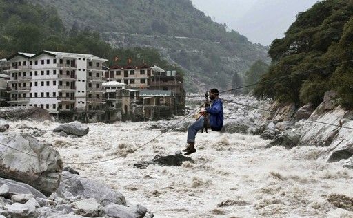 一名印度男子靠繩索渡河。 一名印度男子靠繩索渡河。