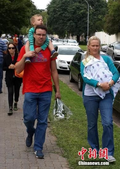圖為一個白人家庭，由父母帶著孩子到曼德拉家門外悼念。中新社發(fā) 宋方燦 攝