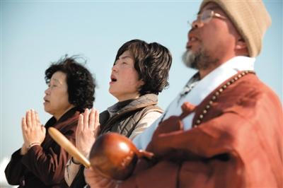 23日，一名僧侶引領(lǐng)人們?yōu)樗勒咂矶\。