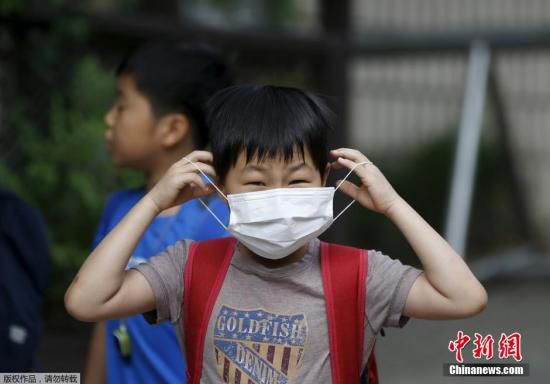 圖為當(dāng)?shù)貢r(shí)間2015年6月8日，韓國(guó)未停課的學(xué)校，學(xué)生課前戴口罩測(cè)體溫。