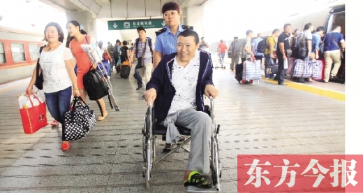 李剛手術(shù)后歸來，在車站工作人員幫助下走出鄭州火車站站臺  東方今報首席記者 張曉冬 攝