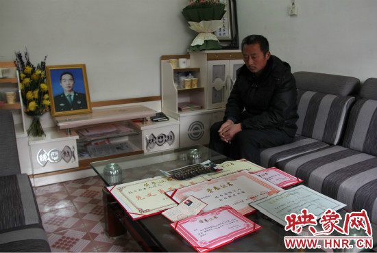 救火英雄鄭春光的父親和兒子獲得榮譽證書。