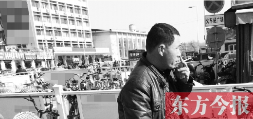 一男子在開封火車站售票廳外吸煙 一男子在開封火車站售票廳外吸煙