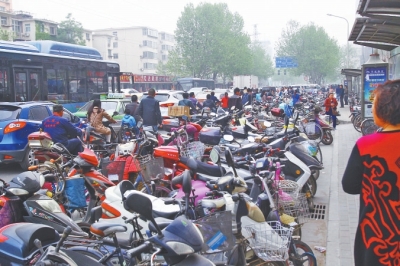 省人民醫(yī)院北門，路邊的公交站牌處停滿非機(jī)動(dòng)車，上、下客只能在快車道上。