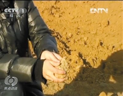 麻剛沙系麻剛石粉碎而成。記者找到一塊麻剛石，一捏就碎成粉末，硬度非常差。央視截圖