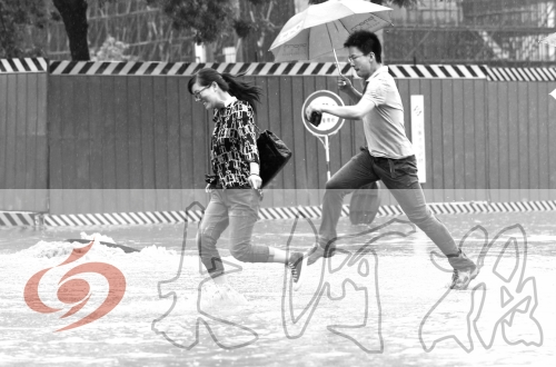 鄭州經(jīng)三路與北環(huán)交叉口處，積水較深，行人們不得不“練輕功”。 記者 白周峰 攝影