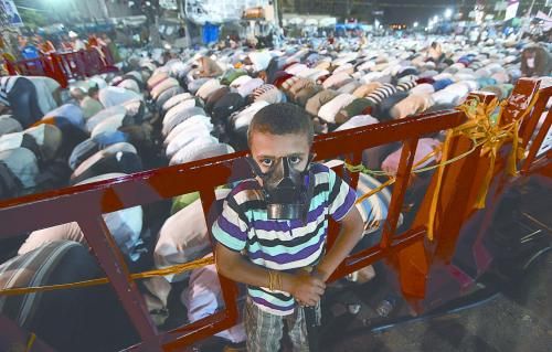 當?shù)貢r間28日晚，在埃及開羅納賽爾城，一名小男孩頭戴防毒面具參加穆兄會的集會示威。