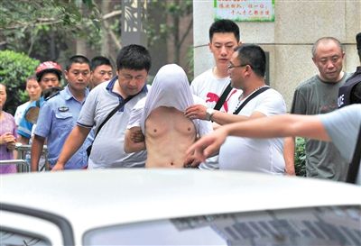 昨日，成都警方抓捕時與毒犯發(fā)生槍戰(zhàn)。一名男犯罪嫌疑人被警方押出。