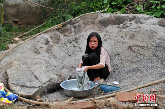 8月9日，云南巧家紅石巖村，10歲的劉鑫蕊在洗自己的衣服